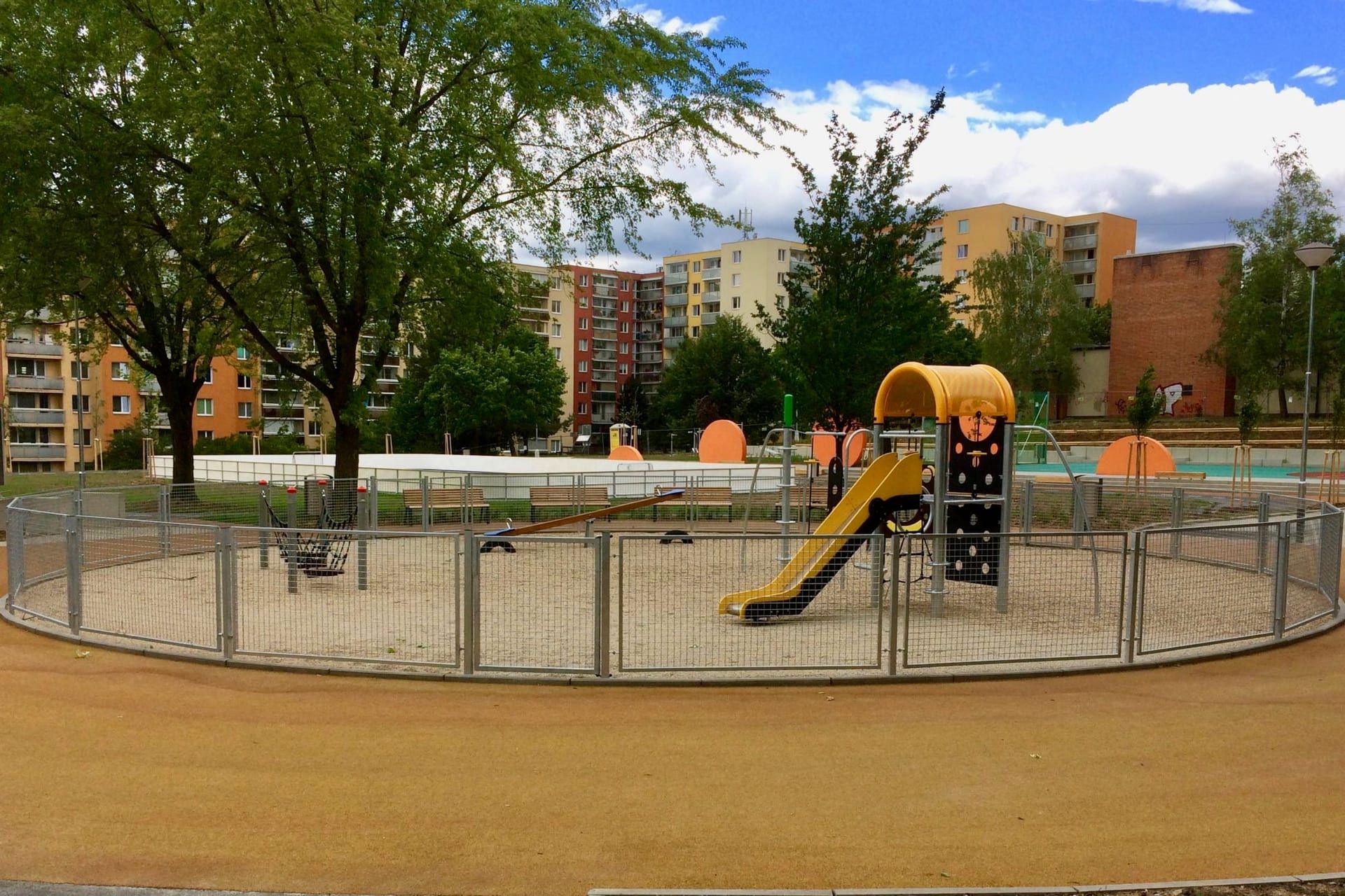 Oplocení dětského hřiště šedými panely na sídlišti